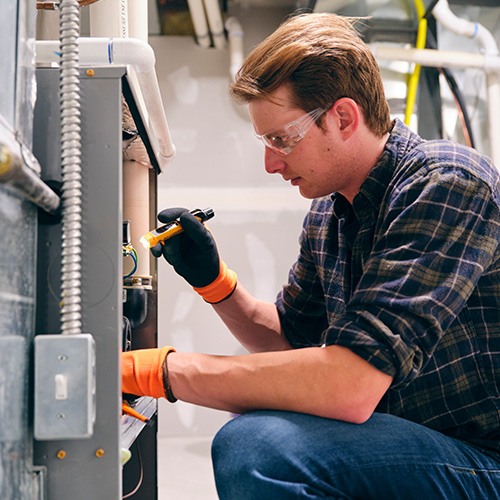 Repair man looking at HVAC unit